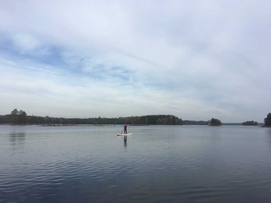 En person som paddlar sup ute på sjön