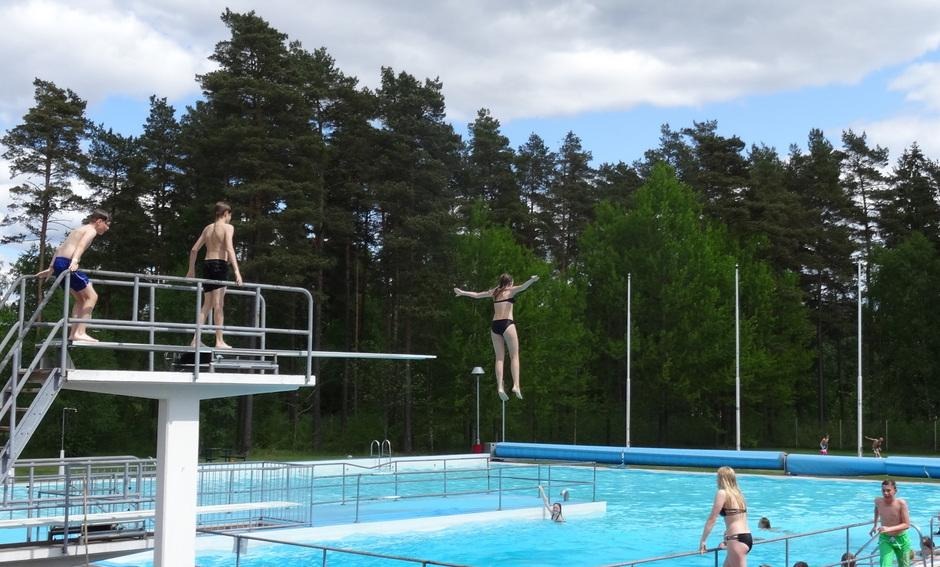 pool med hopptorn och barn som badar