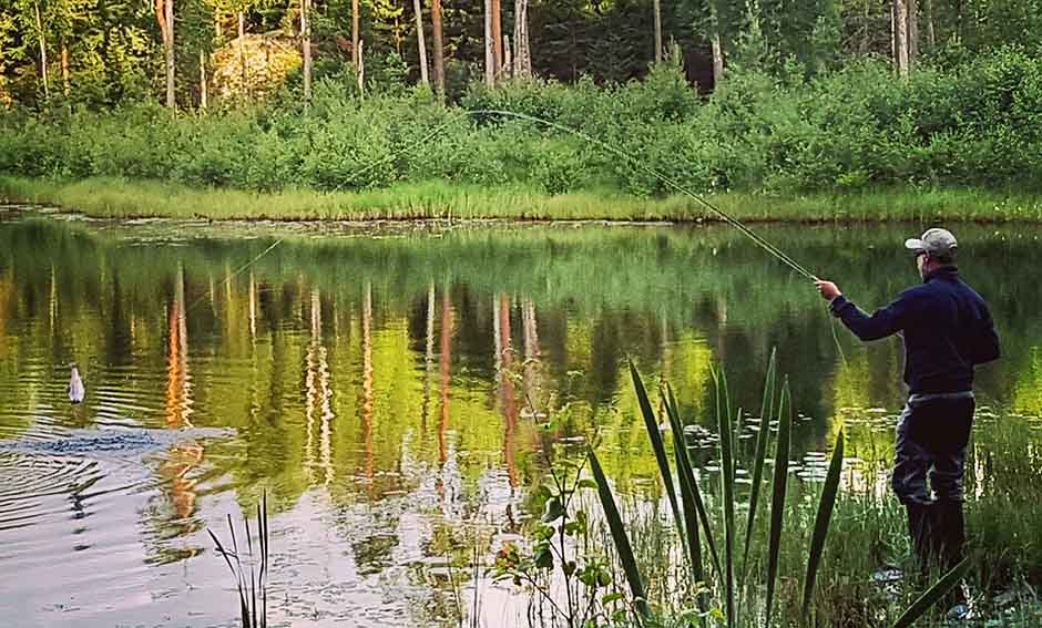 Fiskare står vid sjökanten.