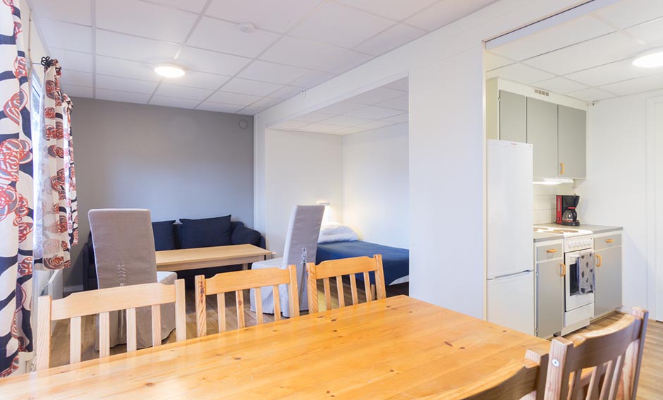 Inuti stuga med matbord soffa & kök.